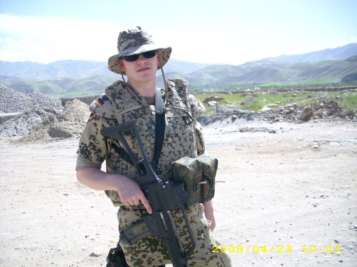 Guts mit seiner Ausrüstung vor der Berglandschaft Afghanistans, 2008
